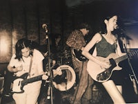 a black and white photo of a group of people playing guitars