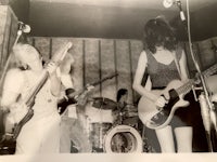 a black and white photo of a group of people playing guitars