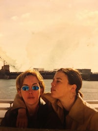 two people posing next to a body of water