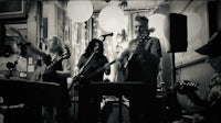 a black and white photo of a group of people playing music