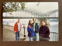 a photo of a group of people posing in front of a bridge